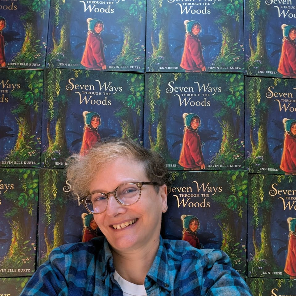 My smiling face in front of a dozen copies of Seven Ways Through the Woods.